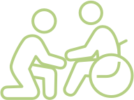 Outline of a person kneeling next to another person in a wheelchair, indicating assisted living.